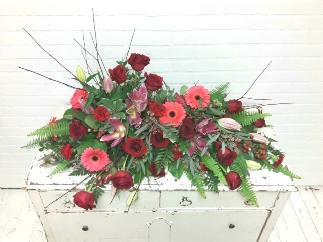 Rich Reds Crescent Style Top Casket Spray